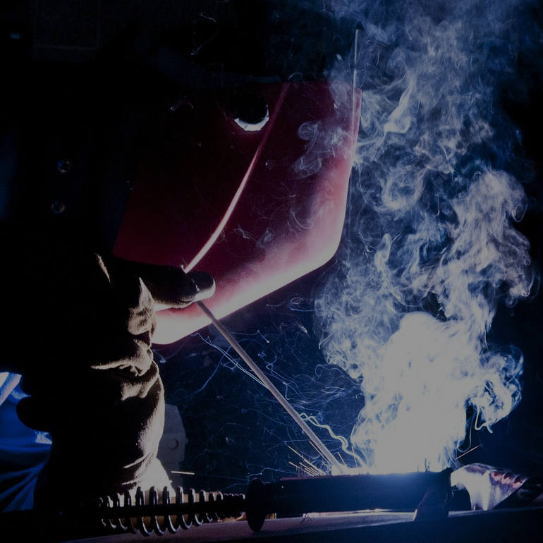 person welding pipe